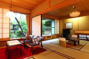 Habitación japonesa con mesa y sillas en Yudanaka Yumoto, en Yamanouchi