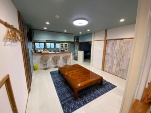 ein Wohnzimmer mit einem Couchtisch auf einem blauen Teppich in der Unterkunft やどかり852 in Manazuru
