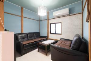 een woonkamer met een leren bank en een tafel bij やどかり852 in Manazuru +22 foto's