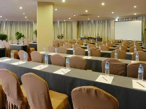 een conferentieruimte met tafels en stoelen en een scherm bij Kunming Long Way Hotel in Kunming