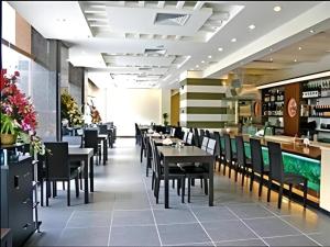 a dining room with tables and chairs in a restaurant at Dongguan Jun Hao Hotel in Dongguan