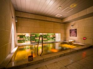 大阪市にあるSuper Hotel Premier Osaka Honmachi Ekimae Natural Hot Springsのシャワー付きのバスタブが備わります。