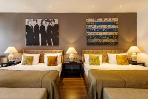 a hotel room with two beds and two lamps at Quentin Boutique Hotel in Berlin