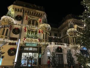 a building decorated with christmas lights and christmas trees at Geany Apartament Ultracentral in Craiova
