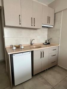 a kitchen with white cabinets and a white dishwasher at Daily-Weekly-Monthly in Kötekli Center 