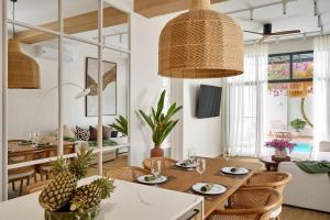 a living room with a table and chairs and a dining room at Onyx Villas by TropicLook in Nai Harn Beach