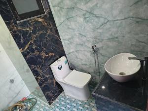 a bathroom with a white toilet and a sink at C-57, Nitin khandelwal in Jaipur