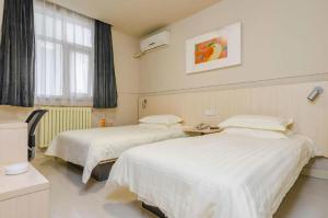 een ziekenhuiskamer met 2 bedden en een raam bij Jinjiang Inn Tai'an Taishan Railway Station in Tai'an +137 foto's