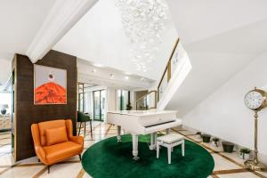 a living room with a white piano and an orange chair at FAM Living- Luxe Penthouse in JBR Marina - Panaromic Sea View in Dubai