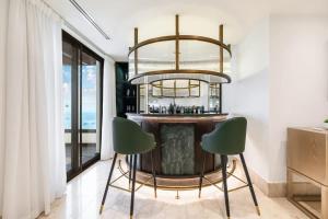 a bar with two green chairs and a chandelier at FAM Living- Luxe Penthouse in JBR Marina - Panaromic Sea View in Dubai +41 photos