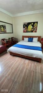 Un dormitorio con una cama grande y suelo de madera. en Phương Thảo Hotel - Near Noi Bai Airport, en Kon Rung (1)