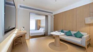 een woonkamer met een bank en een tv bij JI Hotel Beijing Xizhimen in Beijing +22 foto's