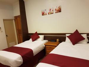 - 2 lits dans une chambre rouge et blanche dans l'établissement Hua Luo Mi No. 35, à Hengchun Old Town