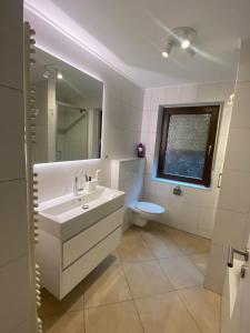 a bathroom with a sink and a toilet and a mirror at Residenz Kipshoven in Niederdorla