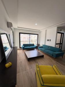 ein Wohnzimmer mit zwei blauen Sofas und einem Tisch in der Unterkunft Résidence Jade in Sousse
