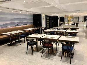 a restaurant with tables and chairs and a painting on the wall at Deacon House Wuxi in Wuxi