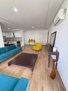 ein Wohnzimmer mit einem blauen Sofa und einem Tisch in der Unterkunft Résidence Jade in Sousse