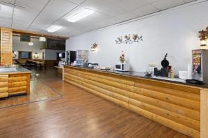 a bar in a restaurant with a counter at Ramada by Wyndham Grayling Hotel & Conference Center in Grayling +37 photos