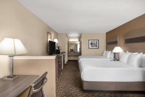 a hotel room with two beds and a desk at Hawthorn Suites by Wyndham Napa Valley in Napa