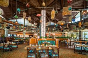 a restaurant with tables and chairs and chandeliers at Hilton Doha in Doha