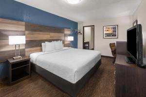 a hotel room with a bed and a flat screen tv at Baymont by Wyndham Downtown Detroit in Detroit