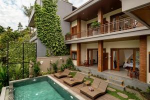 een exterieuraanzicht van een huis met een zwembad bij Orchid Ubud Cottage in Ubud