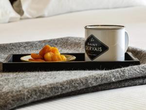 a plate of oranges on a tray next to a mug at Le Saint Gervais Hotel & Spa Handwritten Collection in Saint-Gervais-les-Bains +108 photos