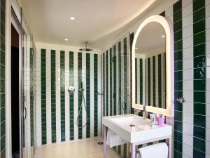 een groene en witte badkamer met een wastafel en een spiegel bij Mama Shelter Dijon in Dijon +146 foto's