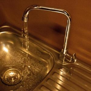 een gootsteen met water uit een kraan bij Lodge Raven in Liyama