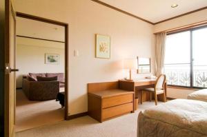Una habitación de hotel con un dormitorio con escritorio y ventana. en HOTEL WINDSOR, en Nakatsugawa 178 fotos más