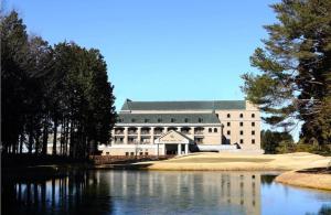 un gran edificio con un lago frente a él en HOTEL WINDSOR, en Nakatsugawa