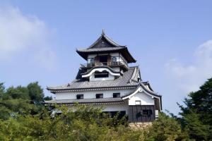 a large white building with a clock tower at Inuyamakan in Inuyama