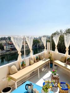a balcony with a couch and a view of the water at Turtle Hostel Udaipur- 10 mtr from Lake in Udaipur