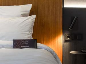 a hotel room with a bed with a book on it at Mercure Palanga Vanagupe Resort & SPA in Palanga +283 photos