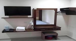 a mirror on a wall with a television on it at Admiral Hotel in Kampong Lumut Kiri