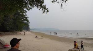 een groep mensen die op een strand staan bij Mynubeholidays - NTCPD in Kampong Tanah Merah