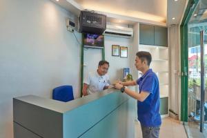 two men standing at a counter in a barber shop at Swing & Pillows @ PJ KD in Sungai Way