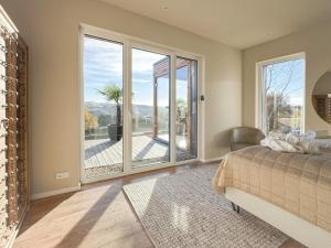 ein Schlafzimmer mit einem Bett und einem großen Glasfenster in der Unterkunft LuxApart Eifel mit privater Sauna in Harscheid