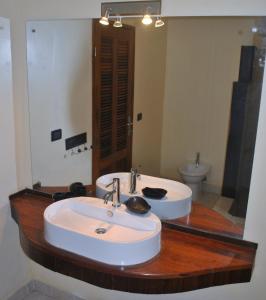 a bathroom with two sinks and a large mirror at Hotel Arc En Ciel in Dzamandzar