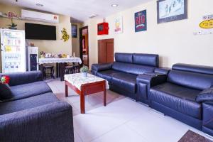 a living room with blue couches and a table at Station Hotel Klang in Klang