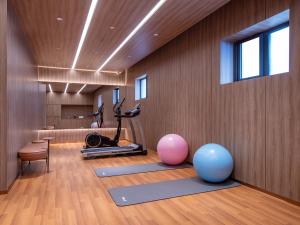 a room with a gym with a treadmill and exercise balls at Orange Hotel Beijing South Railway Station South Square in Beijing