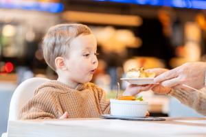 un enfant assis à table mangeant une assiette de nourriture dans l'établissement Czarny Kamień Resort & SPA, à Szklarska Poręba 92 autres photos