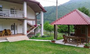 une maison avec une terrasse couverte et un banc dans la cour dans l'établissement Apartment Mitric, à Plužine
