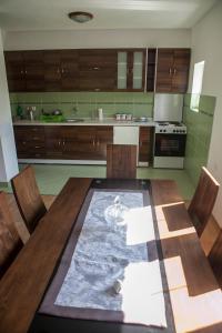 a kitchen with a wooden table with chairs at Apartment Mitric in Plužine
