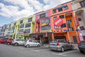 una fila de edificios con coches estacionados en un estacionamiento en SPOT ON 89788 Musafir Transit Hotel, en Nilai