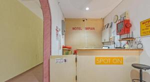 a kitchen with a counter and a refrigerator in a room at SPOT ON 91178 Motel Impian in Seri Manjung
