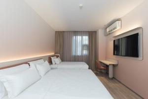 Ένα ή περισσότερα κρεβάτια σε δωμάτιο στο Hanting Hotel Beijing Guanyuan Bridge