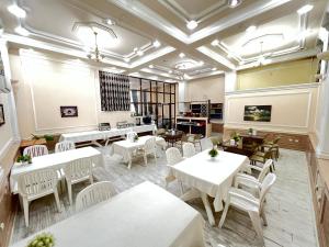 a restaurant with white tables and white chairs at The green regency in Toshkent-Passajir Bekati