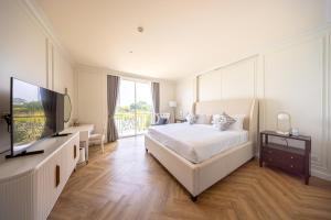 une chambre blanche avec un lit et une télévision dans l'établissement Olivia Boutique Thailand, à Ban Bang Kraba