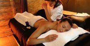 een vrouw die op een handdoek ligt in een massageruimte bij Hotel Mia Cara & Spa in Florence